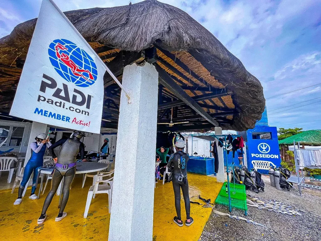 패션 다이브 센터의 PADI 깃발과 프리다이빙 슈트를 입고 준비하는 다이버들