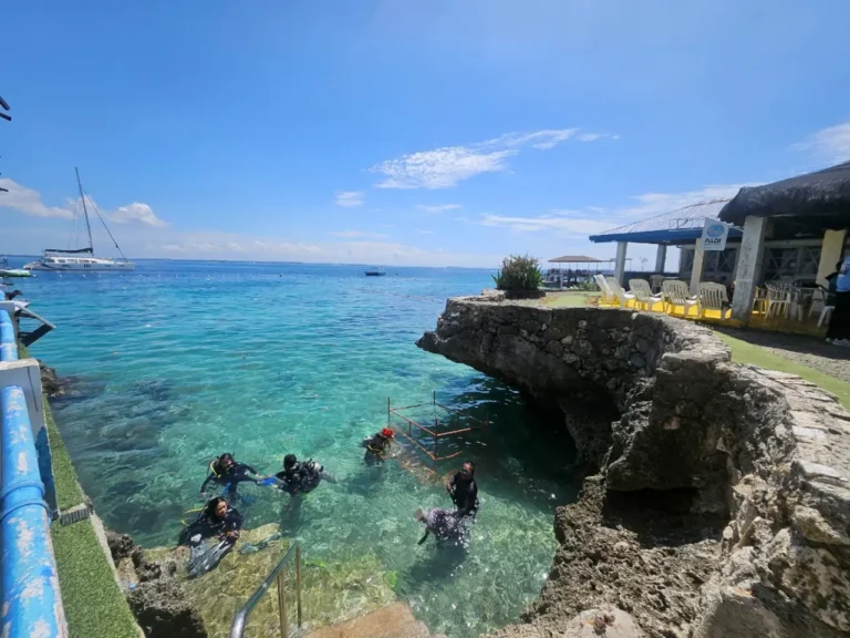Scuba divers at Passion Dive preparing to enter the clear blue water in Cebu after Typhoon Kalmaegi.