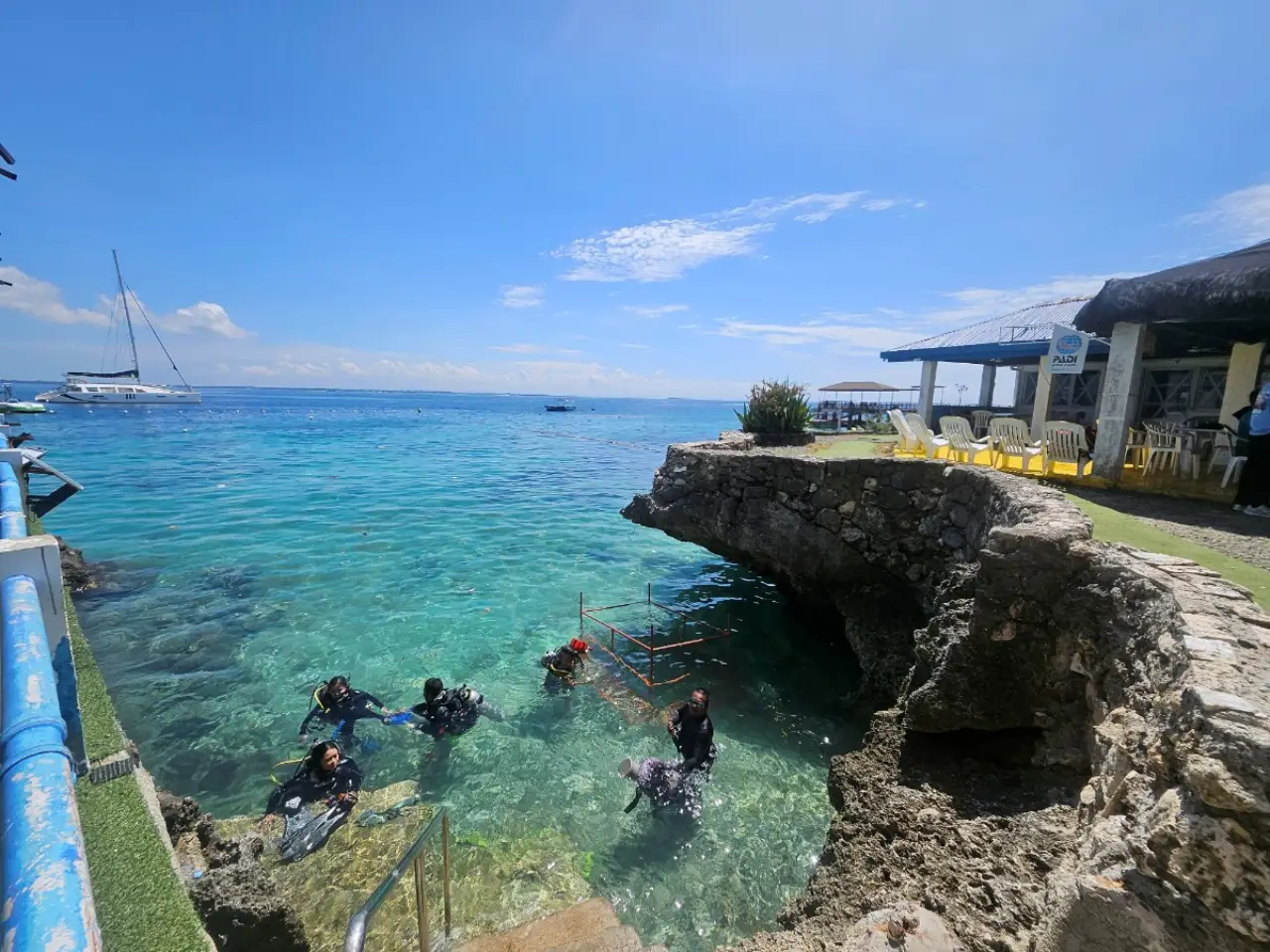 Scuba divers at Passion Dive preparing to enter the clear blue water in Cebu after Typhoon Kalmaegi.